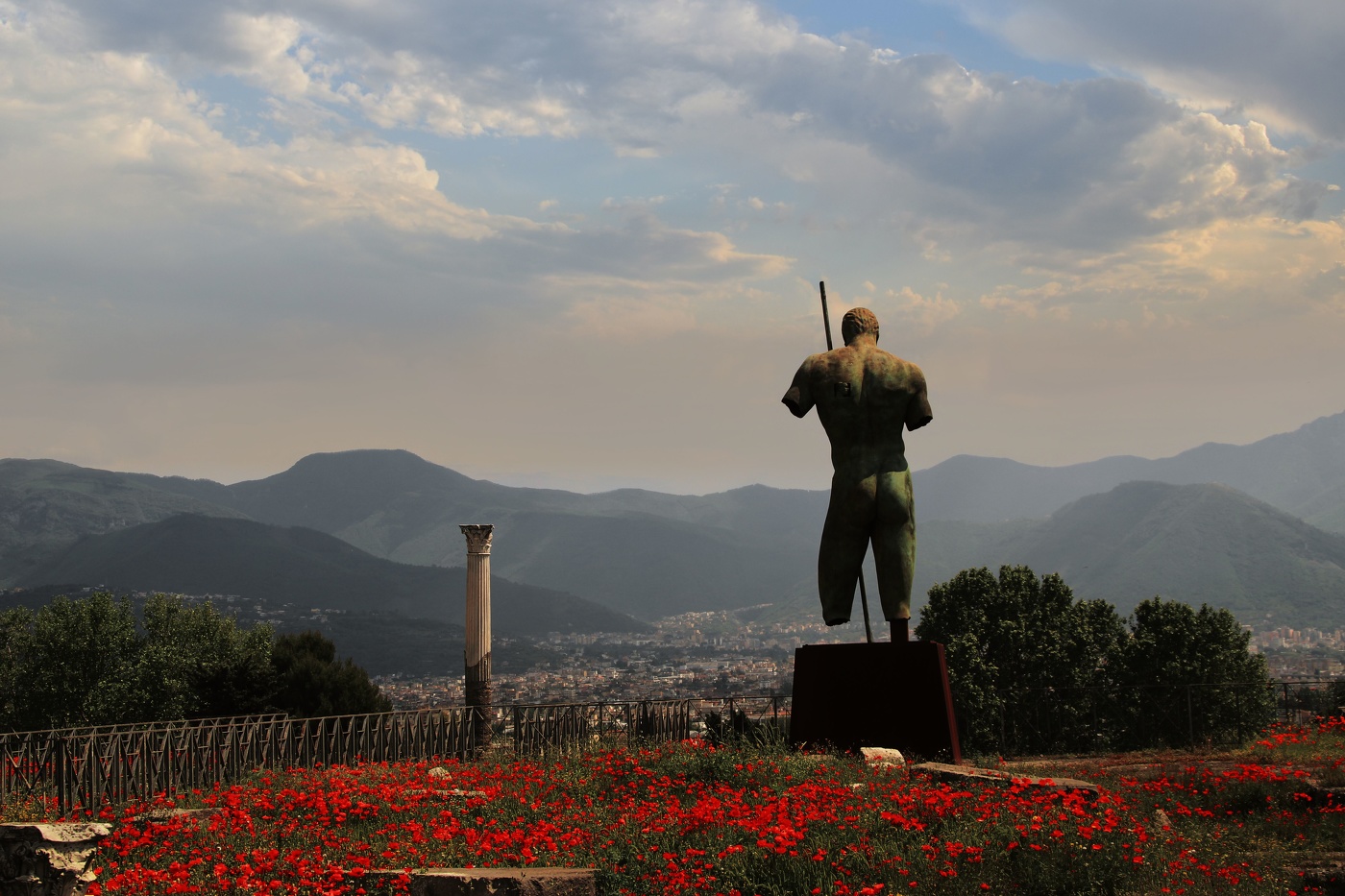 Ruinen von Pompeji und Bronze Statue von Daedalus von Igor Mitoraj unter Mohnblumen und grünes Gr