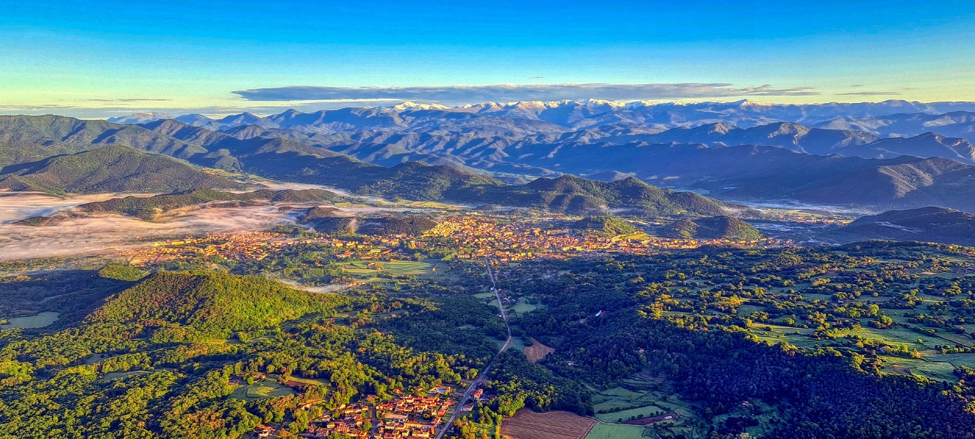 Santa Pau - vol globus (Olot i els Pirineus al fons) - La Garrotxa