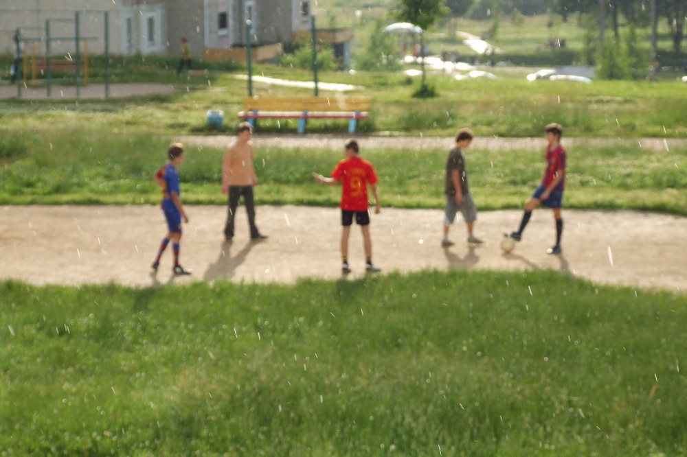 Fussball in der Sonne Pfützen