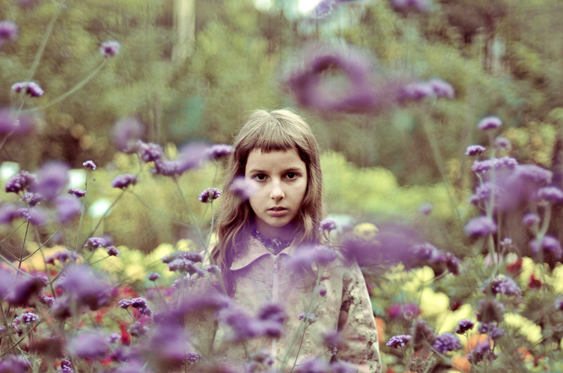 Ein Mädchen in einem Blumengarten.