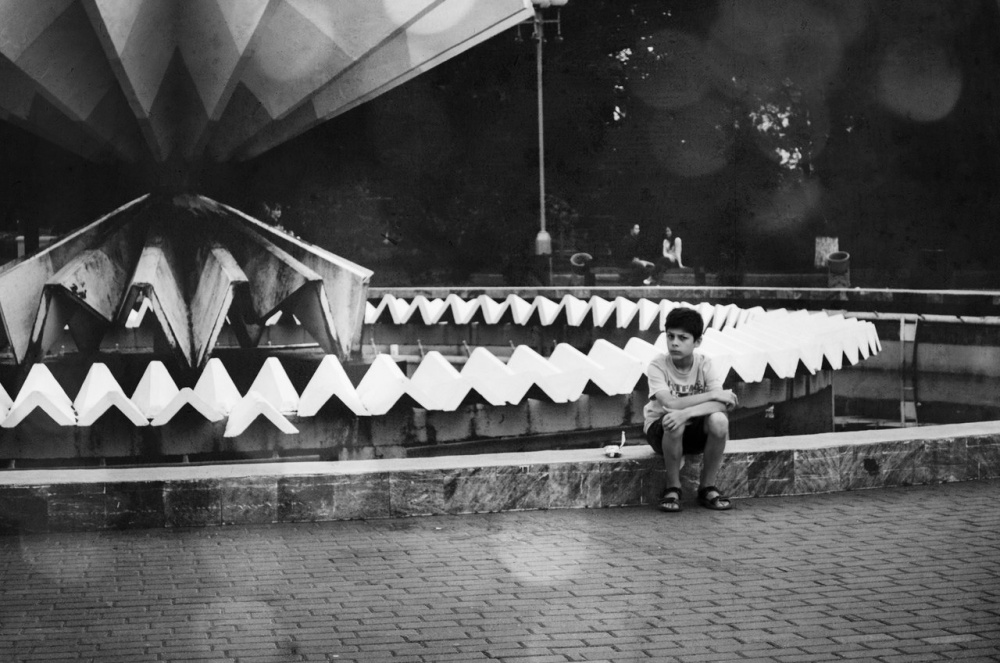 Ein Brunnen und ein Junge.