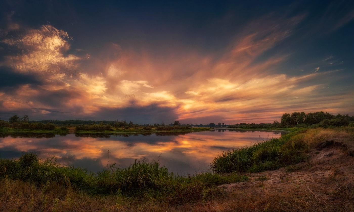 Die Explosion der Sonnenuntergang über dem Fluss